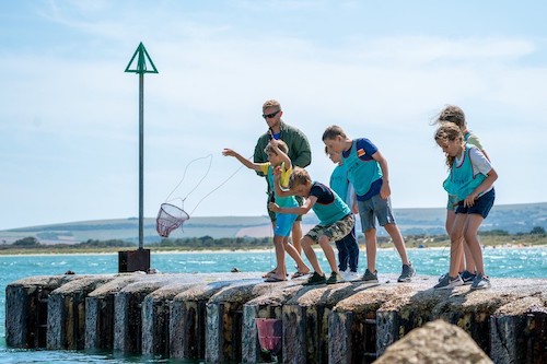 working with children on a crabbing session as an outdoor instructor