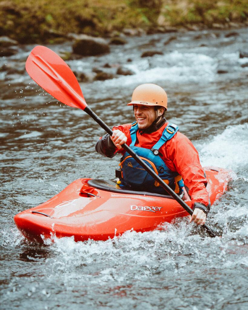 a picture of a man kayaking in river